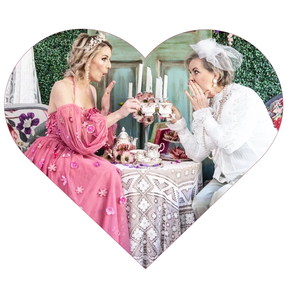 Two guests sharing a toast at a styled high tea table